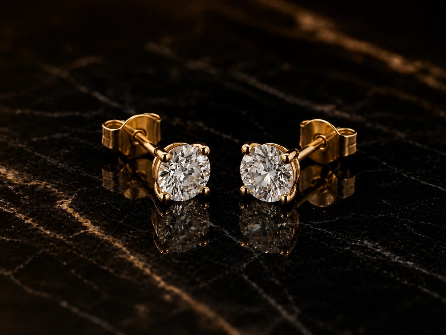 Kolczyki solitaire z diamentami w żółtym złocie, oprawa 4 pazurki — ujęcie pod kątem 3/4