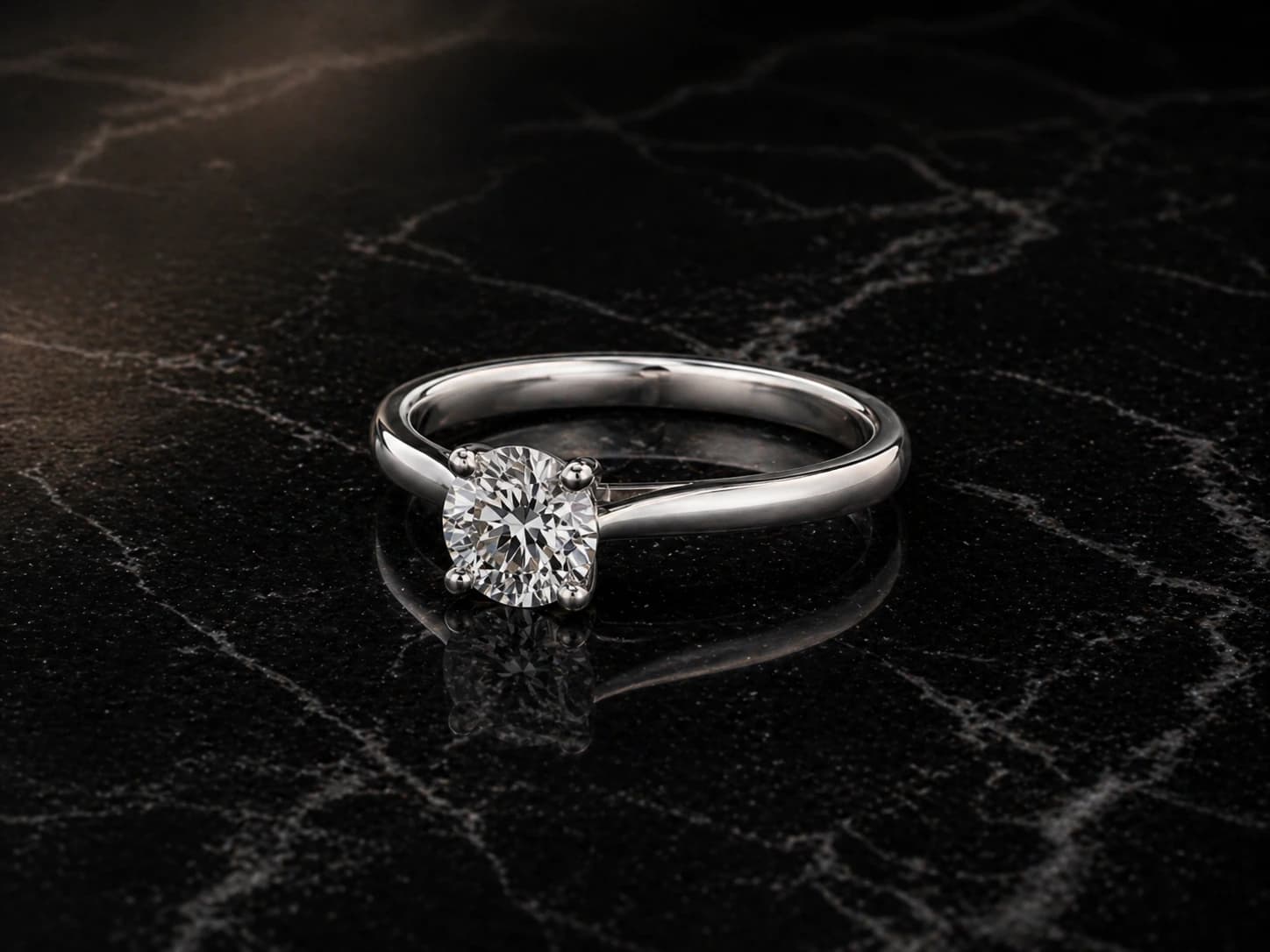 Pierścionek solitaire z diamentem w białym złocie, oprawa 4 pazurki — ujęcie pod kątem 3/4